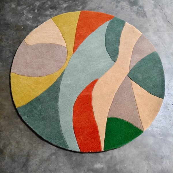 Abstract round wool rug with organic pattern in sage green, terracotta orange, mustard yellow, and beige tones.