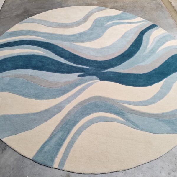 Abstract Hand Tufted Wool Rug with blue wave pattern in round shape.
